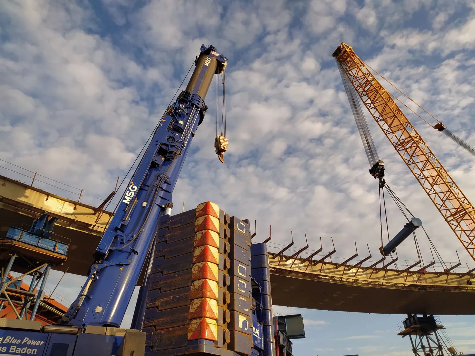 Große Baustelle mit mehreren Baukränen und Baumaschinen aus erhöhter Perspektive